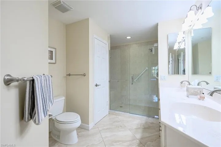 Master Bathroom featuring double vanity, a shower stall, light marble finish floors, and recessed lighting
