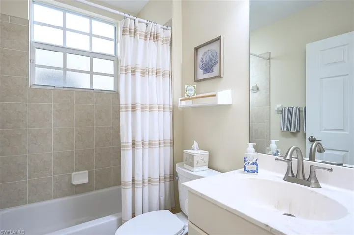 Full bath with shower / bath combo with shower curtain and vanity