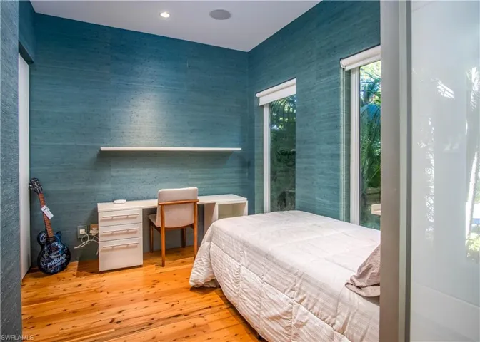 Bedroom featuring hardwood / wood-style floors and built in desk