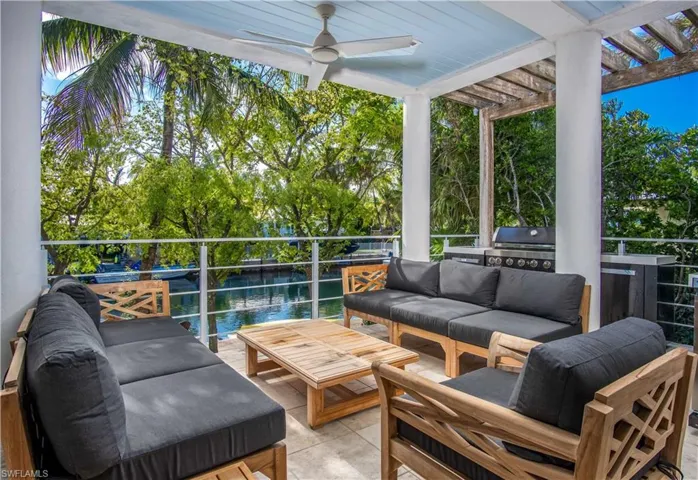 View of patio with ceiling fan, an outdoor living space, exterior kitchen, a water view, and a pergola