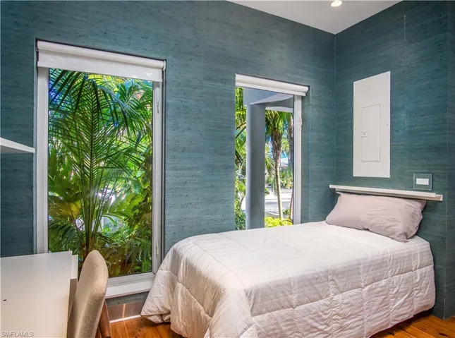 Bedroom featuring electric panel and wood-type flooring