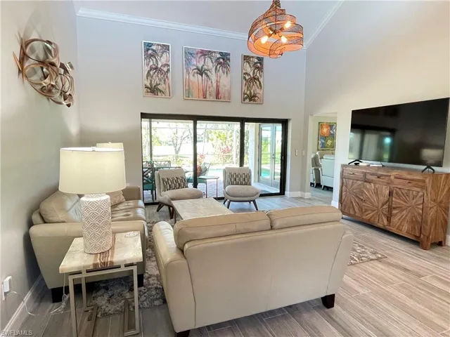 Living room with ornamental molding, a towering ceiling