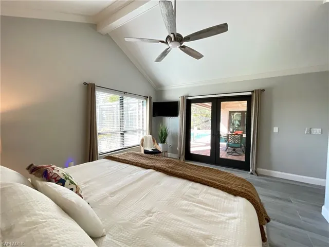 Bedroom featuring high vaulted ceiling, beamed ceiling, wood-type flooring, ceiling fan, and french doors