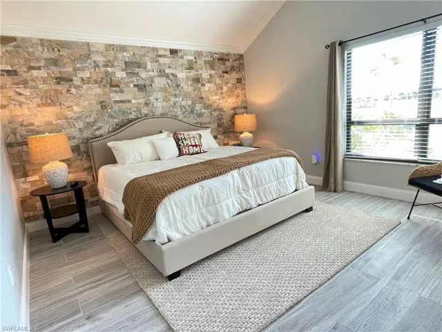 Primary Bedroom featuring crown molding and vaulted ceiling