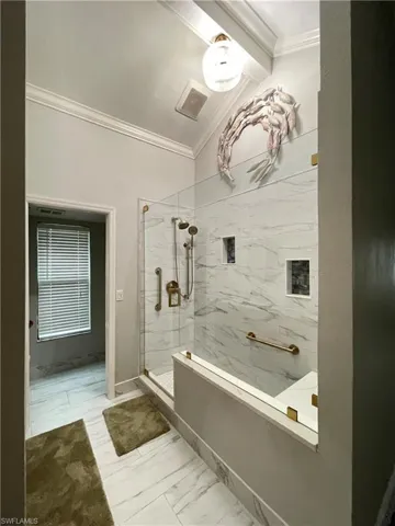 Bathroom with tiled shower and ornamental molding
