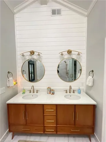 Bathroom featuring vanity, vaulted ceiling, and crown molding