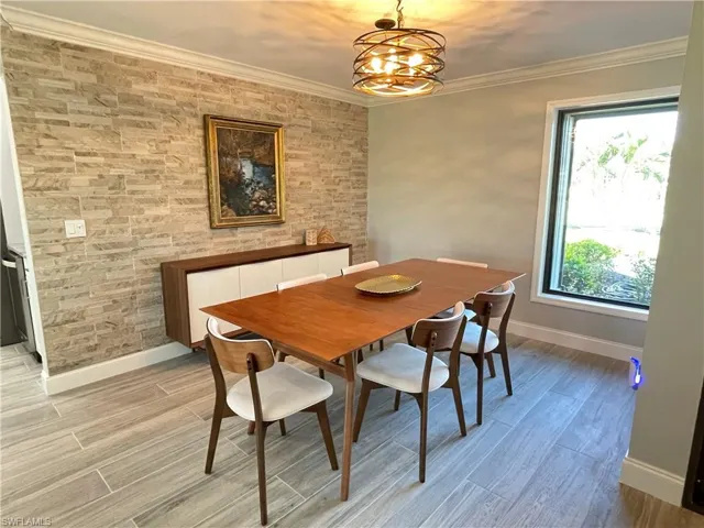 Dining area with ornamental molding and a chandelier