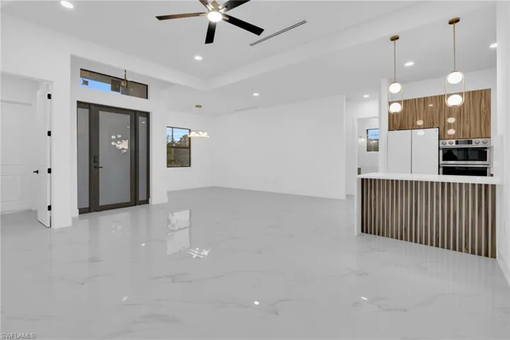 Unfurnished living room with light marble finish flooring, recessed lighting, and a ceiling fan