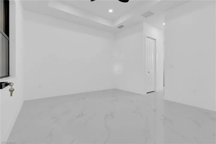 Unfurnished room with a raised ceiling, recessed lighting, and ceiling fan