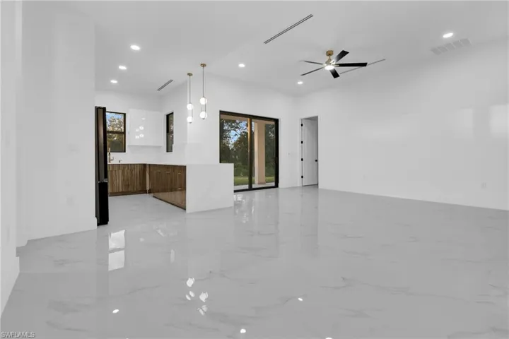 Unfurnished living room featuring light marble finish floors, recessed lighting, and ceiling fan