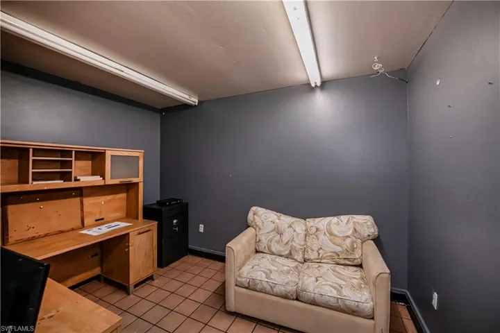 Living area with beamed ceiling, baseboards, and light tile patterned floors