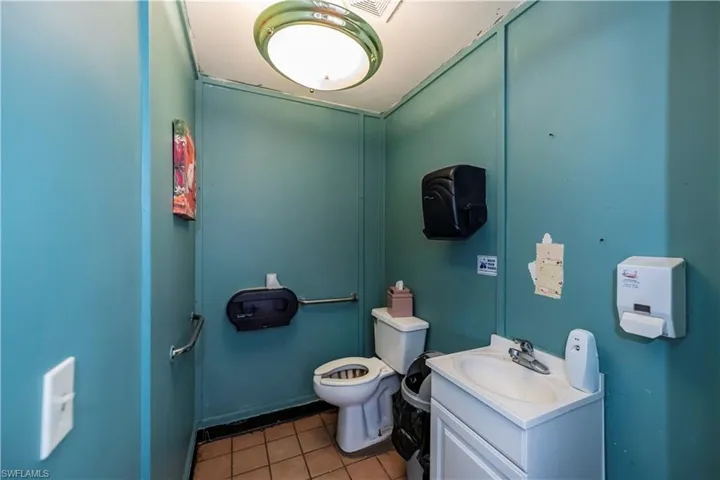 Bathroom with tile patterned flooring, visible vents, vanity, and toilet