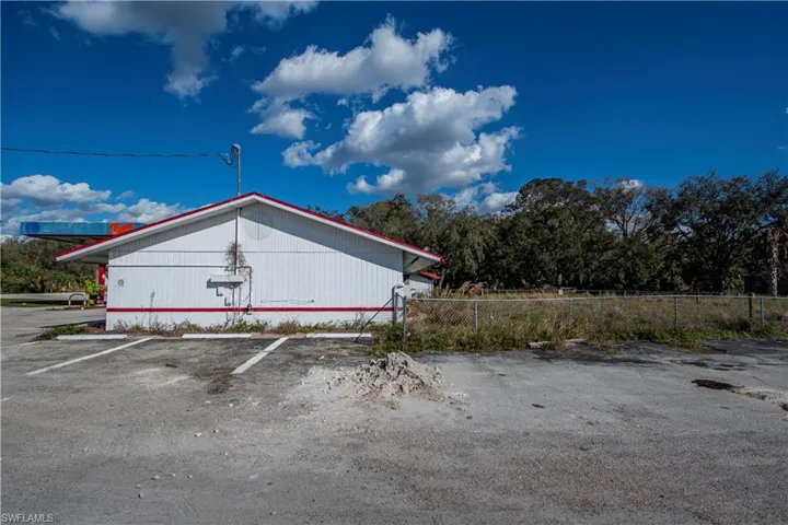 View of side of property featuring uncovered parking and fence