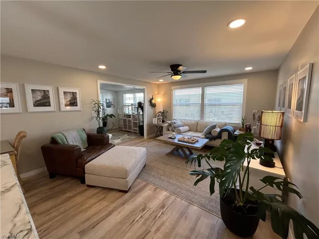 Living room featuring ceiling fan and light hardwood / wood-style flooring