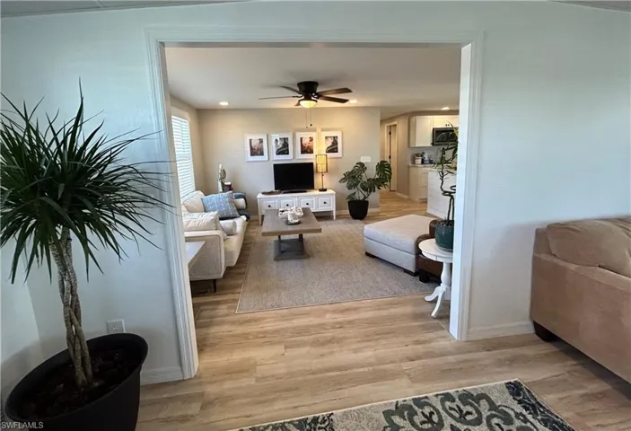 Living room with light hardwood / wood-style flooring and ceiling fan