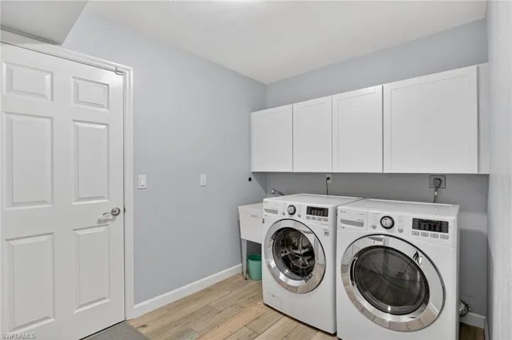 Dedicated laundry area featuring wood-finish flooring