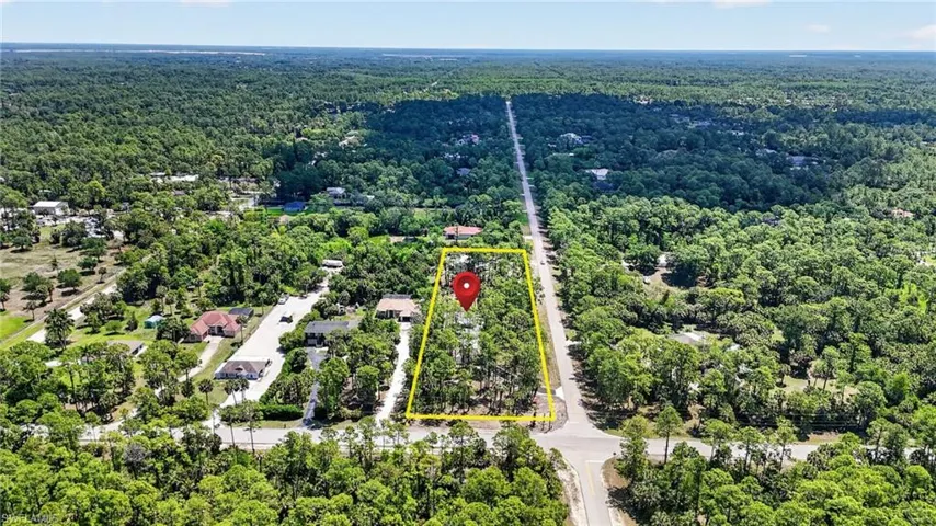 Aerial view showcasing a rectangular parcel of land, bordered by roads on two sides
