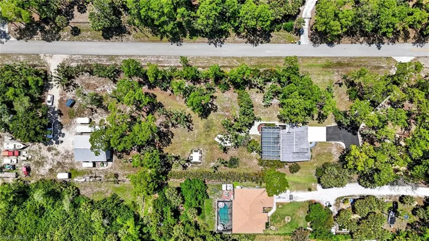 Expansive property featuring mature trees and two distinct structures