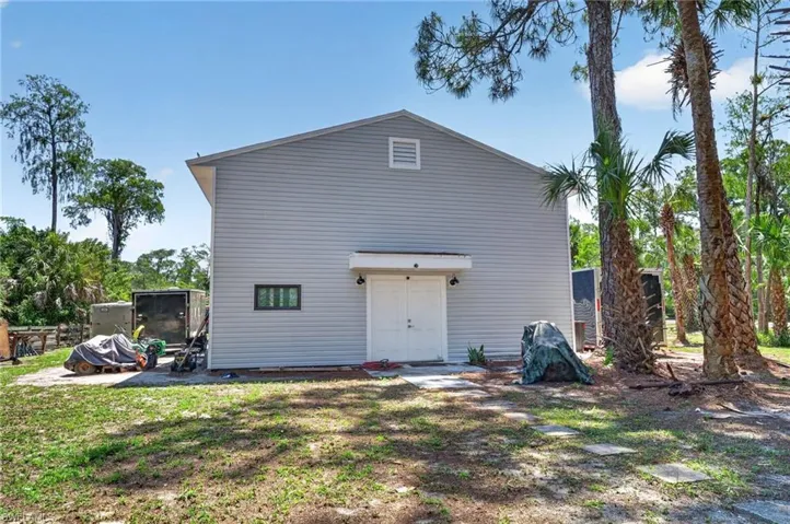Light gray horizontal siding exterior featuring a gable roof and white double entry doors