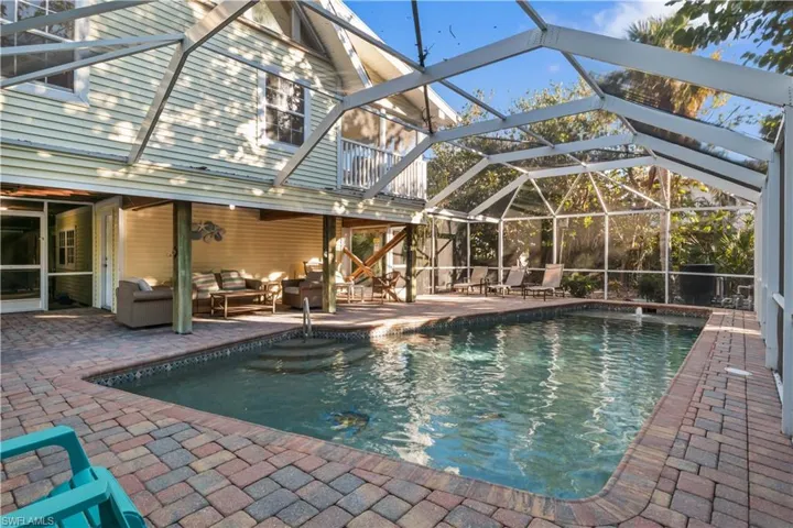 View of swimming pool with outdoor lounge area, and shaded area for comfort.