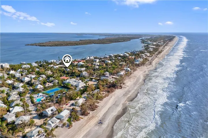 Birds eye view of property with a water view and a view of the beach