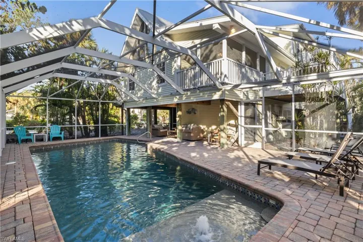 View of pool with a lanai and a patio area.