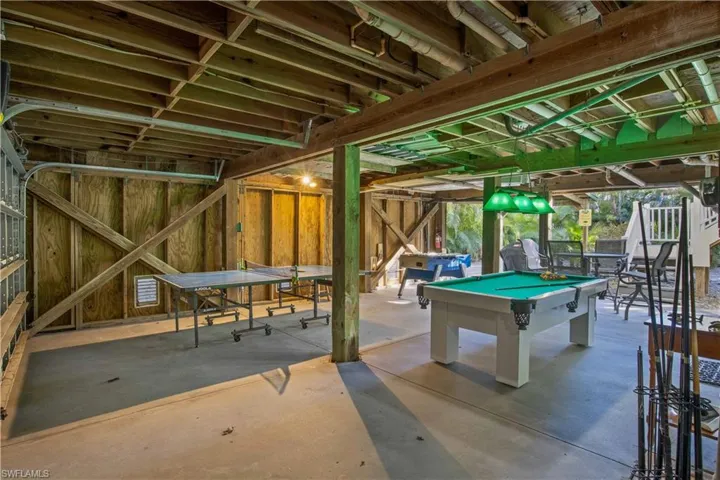 Playroom/garage with concrete flooring and billiards.