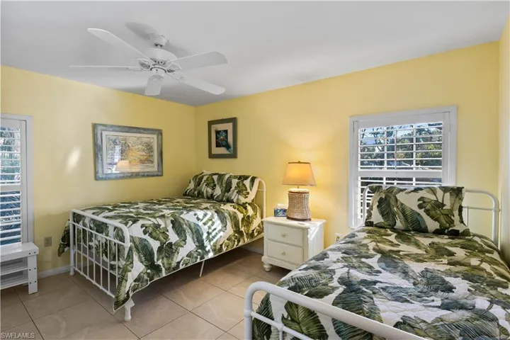 Bedroom featuring multiple windows, ceiling fan, and light tile patterned flooring