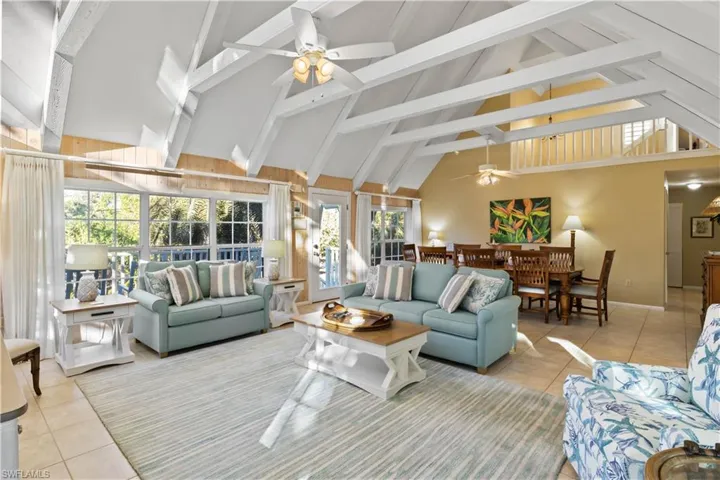 Living room featuring ceiling fan, high vaulted ceiling, and light tile patterned floors.