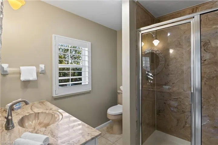 Bathroom with tile patterned floors, vanity and an enclosed shower