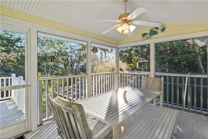 Lanai off of kitchen with ceiling fan and vaulted ceiling.
