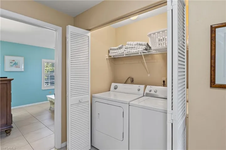 Washroom featuring washer and clothes dryer and light tile patterned floors
