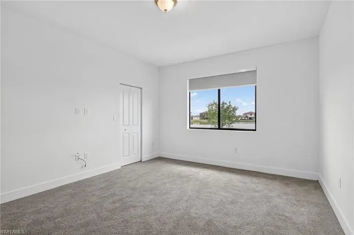Unfurnished room featuring light colored carpet and baseboards