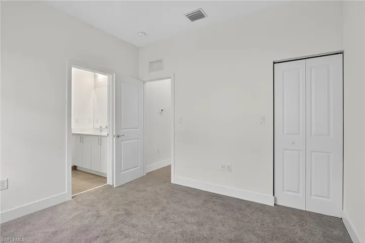 Unfurnished bedroom featuring light carpet and a closet