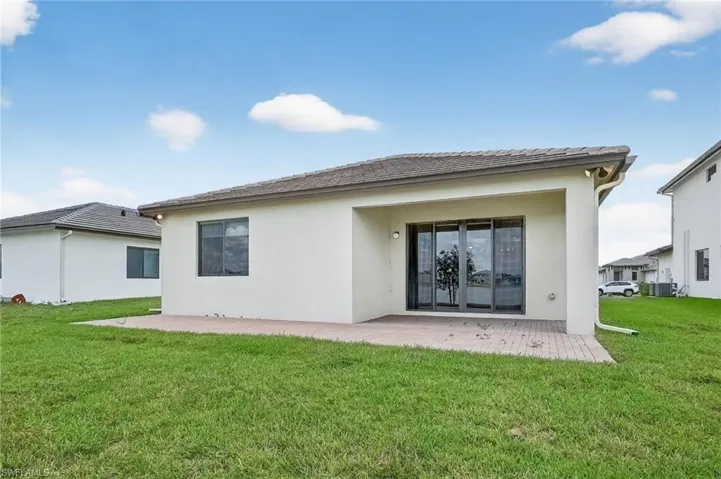 Back of property featuring stucco siding, a yard, and a patio