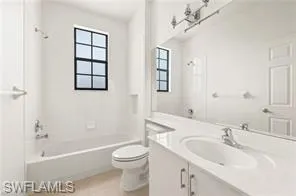Bathroom with vanity, shower / bathtub combination, and light tile patterned flooring