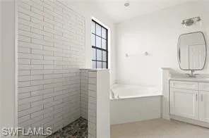 Full bathroom with vanity, a bath, and a walk in shower