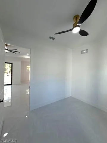 Unfurnished room with a ceiling fan and baseboards