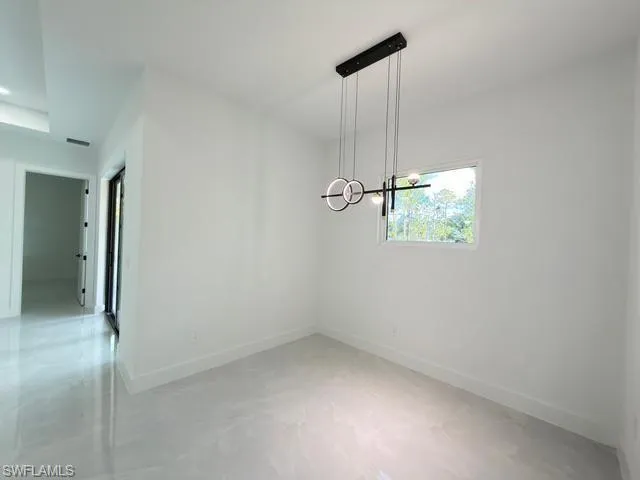 Unfurnished dining area featuring baseboards and finished concrete flooring