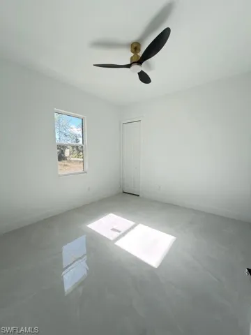 Unfurnished bedroom with a ceiling fan and a closet
