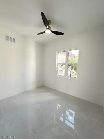 Spare room featuring a ceiling fan and concrete floors