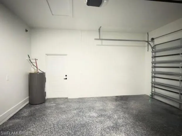 Garage featuring water heater and a garage door opener