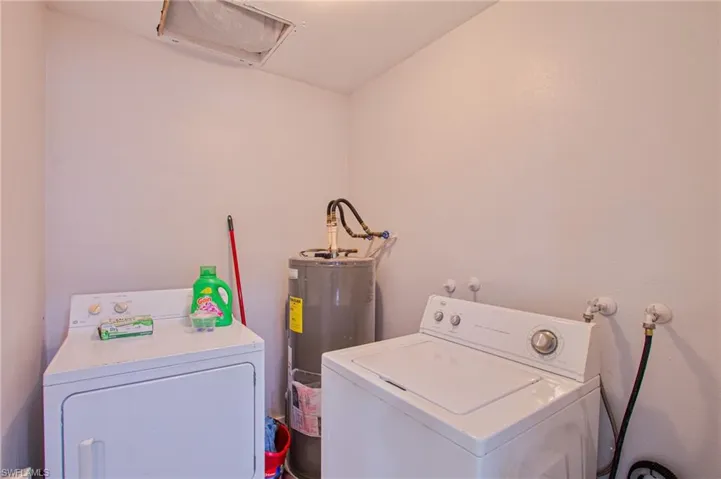 Clothes washing area featuring washer and clothes dryer and water heater