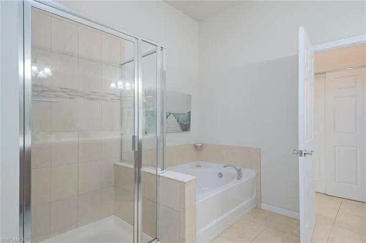 Bathroom with tile patterned flooring and independent shower and bath
