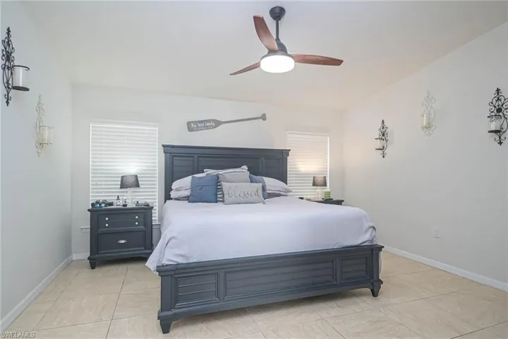 Tiled bedroom featuring ceiling fan