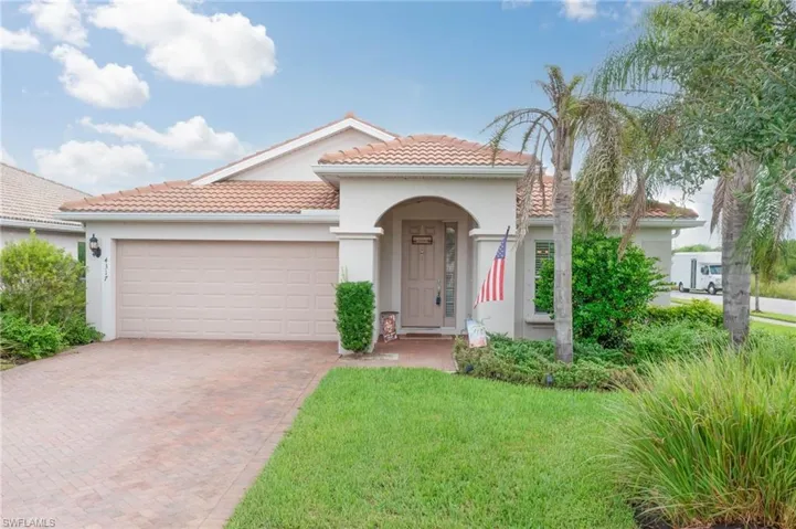 Mediterranean / spanish-style home featuring a garage and a front lawn