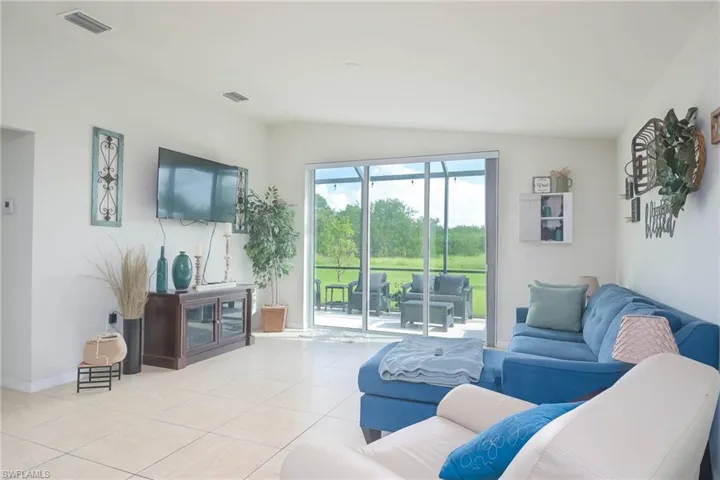 Living room with vaulted ceiling and light tile patterned floors