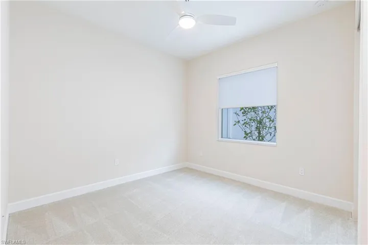 Empty room with light carpet and ceiling fan