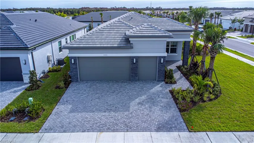 View of front of home featuring a garage, a front lawn, and central AC unit