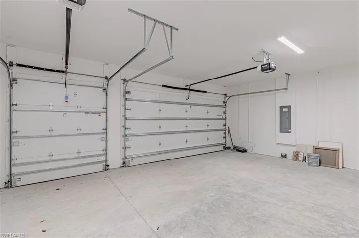 Garage featuring a garage door opener and electric panel